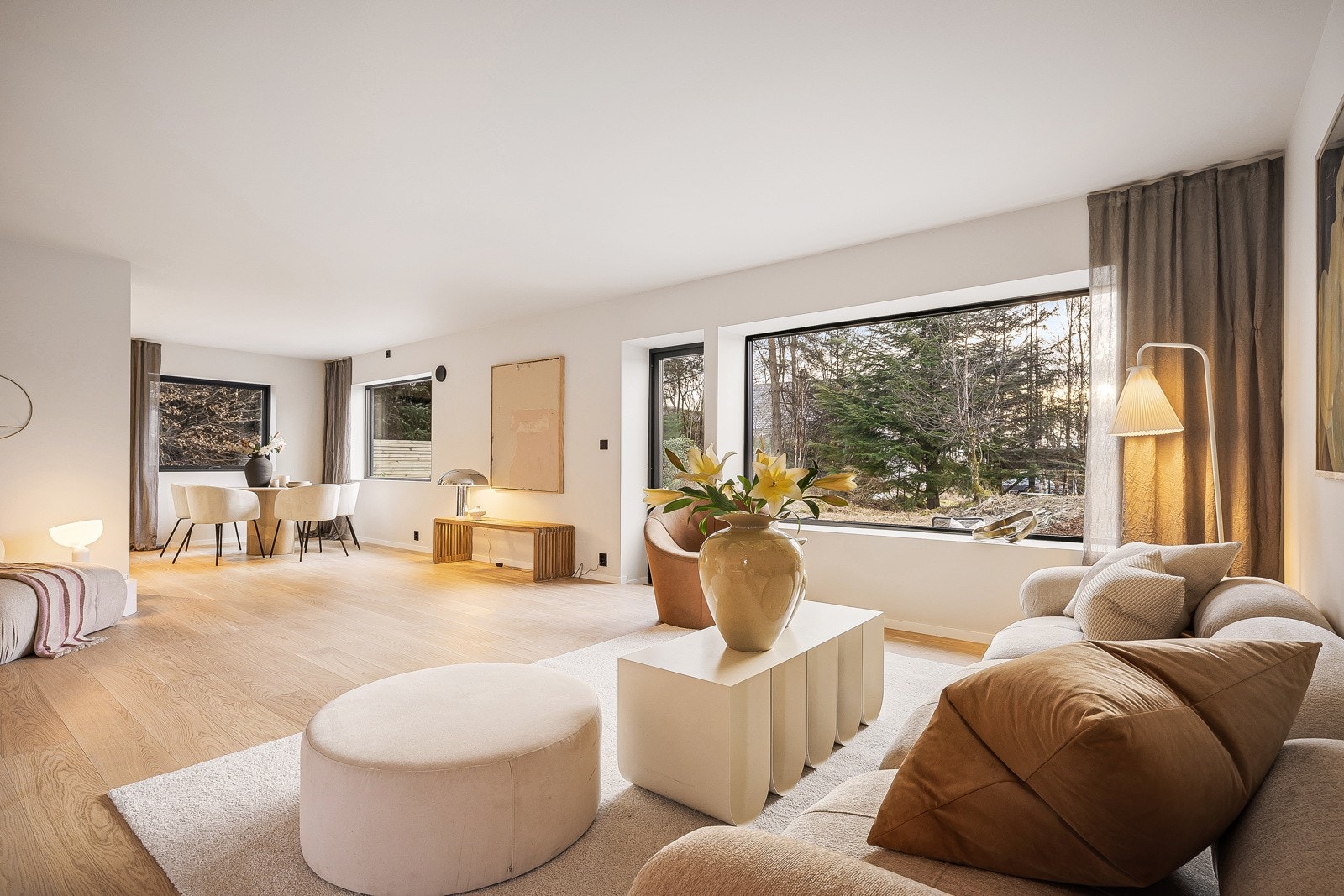 Store vindusflater på 3 vegger gir godt naturlig lys i stuen Galleribilde