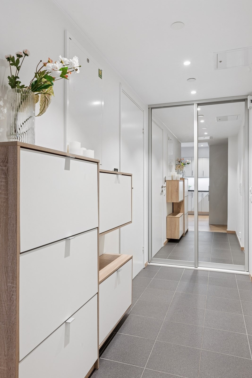 Gangen gir et ryddig og godt førsteinntrykk, med god plass til yttertøy og sko. Praktisk skyvedørsgarderobe sørger for rikelig med oppbevaring og bidrar til en oversiktlig og funksjonell entré. Galleribilde