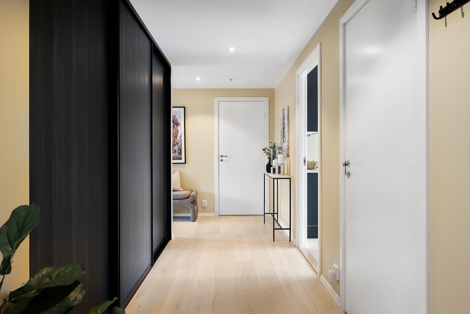 Lys og innbydende entre med malte, slette flater og 1-stavs parkett som gjengår i hele leiligheten som gir et umiddelbart helhetlig inntrykk. Galleribilde