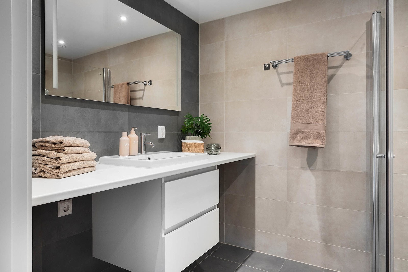 Stilrent, flislagt bad med termostatstyrt vannbåren gulvvarme og downlights. Galleribilde