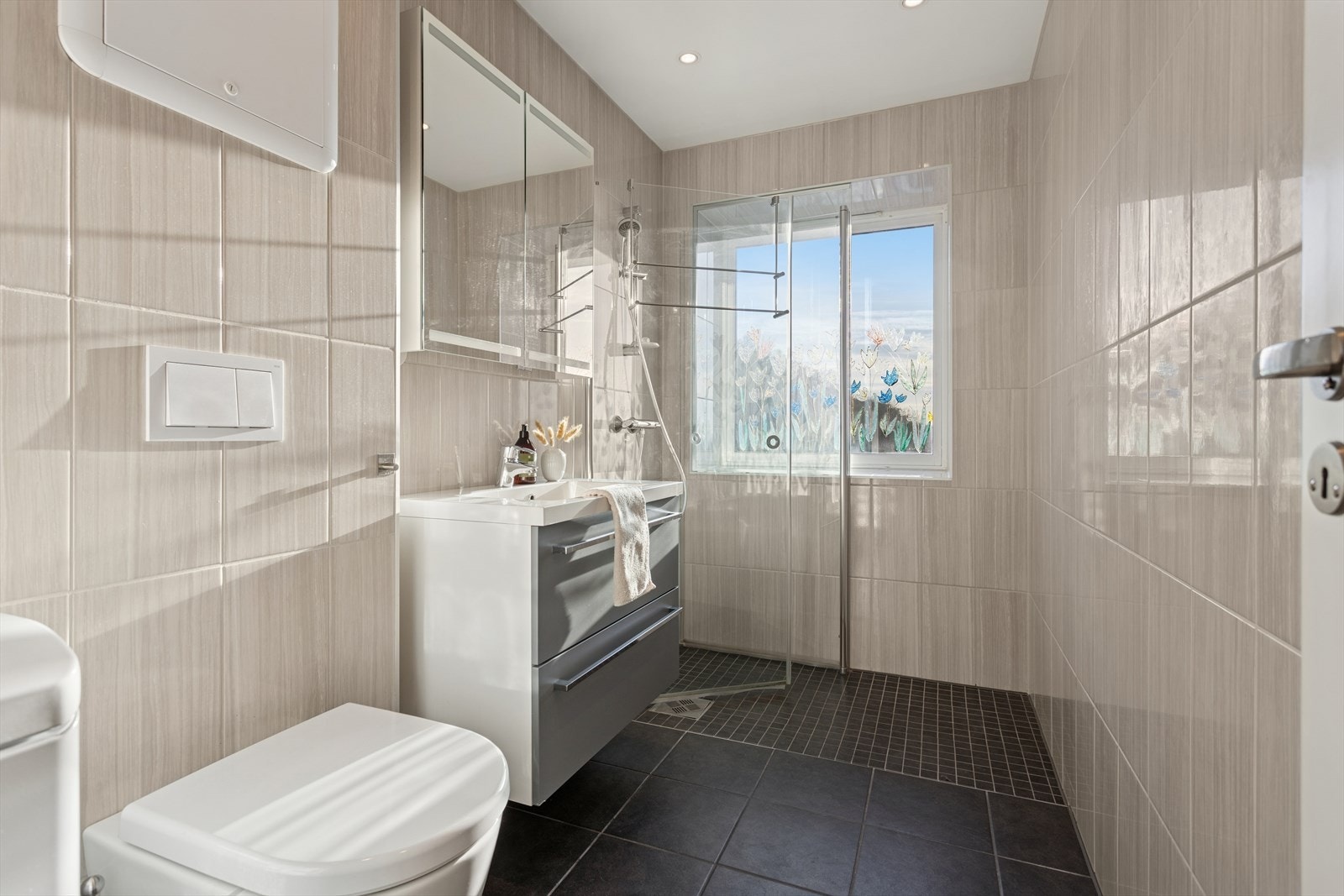 Rommet er utstyrt med vegghengt toalett, opplegg for vaskemaskin, samt servant med praktisk innredning og dusj. Galleribilde