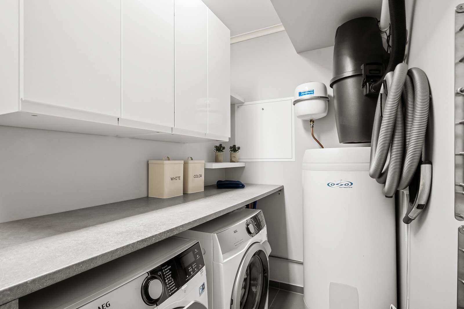 Vaskerommet ligger vegg i vegg med badet og har flislagt gulv. Her er det skapinnredning og benkeplate i laminat. Galleribilde