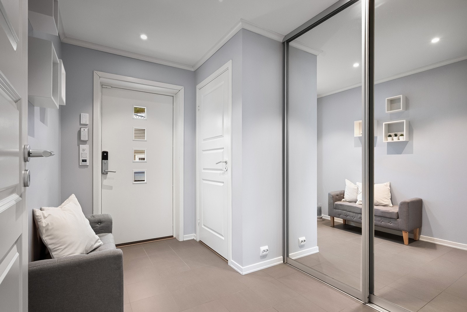 Entréen er innbydende med flislagt gulv og varmekabler. Her er det montert en stor skyvedørsgarderobe med speilfronter som gir god oppbevaringsplass. Galleribilde