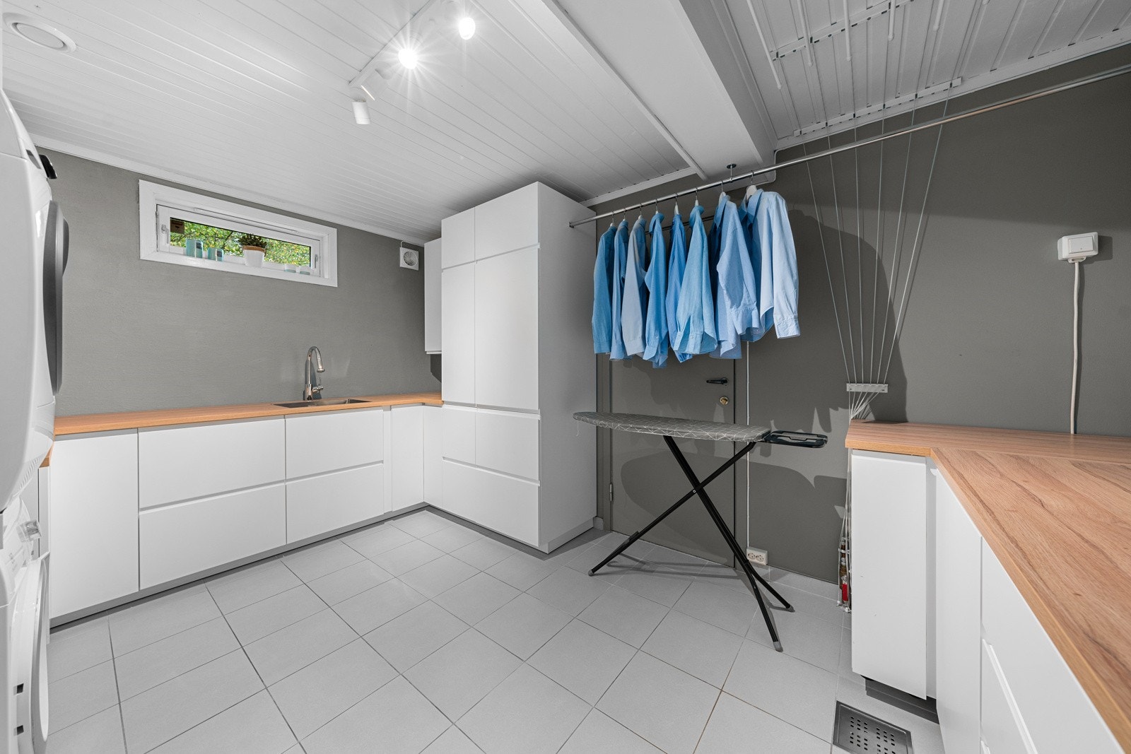 Stort vaskerom med flislagt gulv og svært godt med oppbevaringsplass.Det er også en dør som går til hybelen. Galleribilde