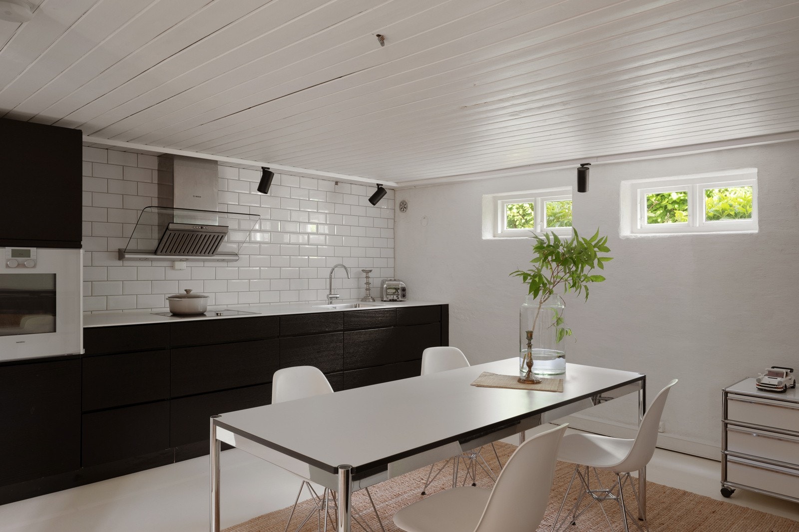 Kjøkkenet fra Kvik har sorte fronter, hvit benkeplate med underlimt kum og hvitevarer fra Gaggenau og Siemens. Galleribilde