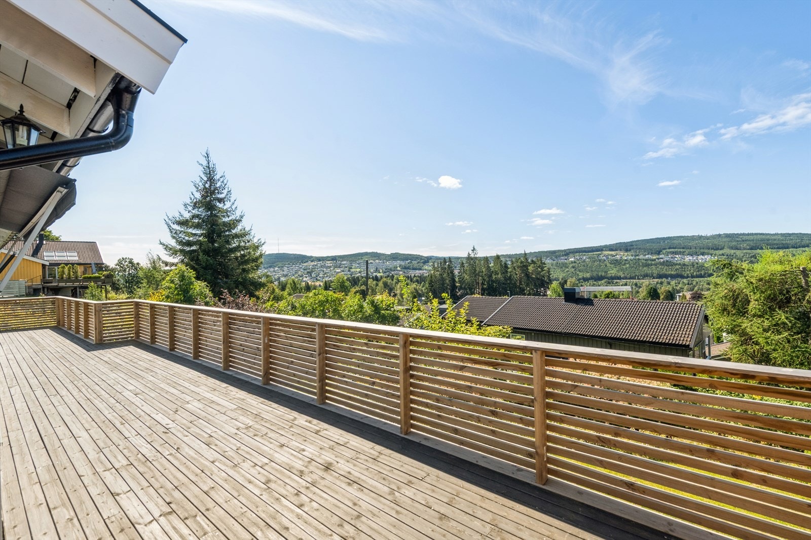 Utgang fra stue til solrik terrasse med flott utsikt mot byen og landskapet. Galleribilde