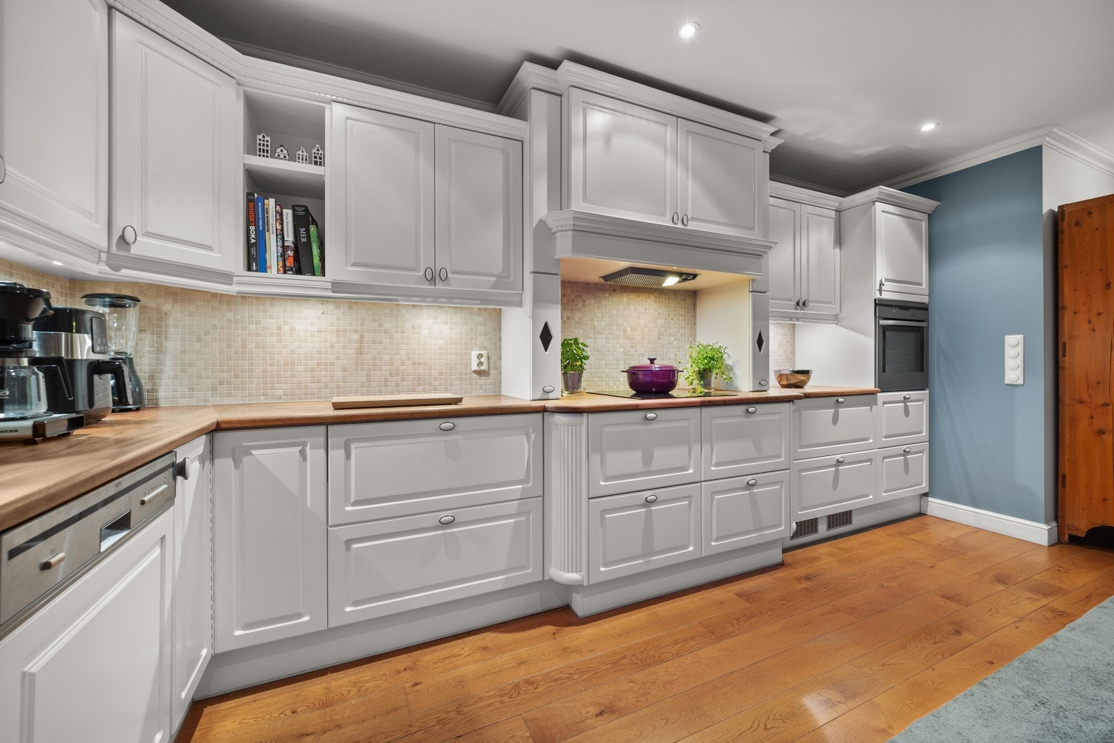 Kjøkkenet er naturlig integrert i oppholdsrommet og har innredning langs to vegger. Rikelig med både arbeidsplass og oppbevaring i skap og skuffer. Galleribilde