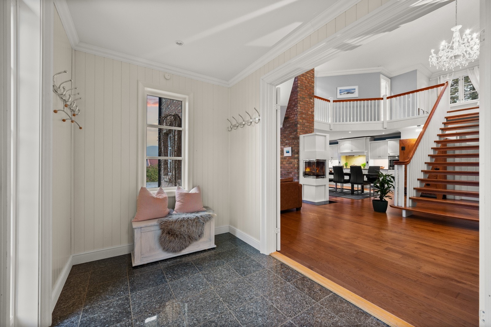 Særdeles flott inngangsparti med vindfang og et åpent allrom i hovedetasjen som gjør inngangspartiet til et praktisk knutepunkt for både hverdag og selskap. Galleribilde