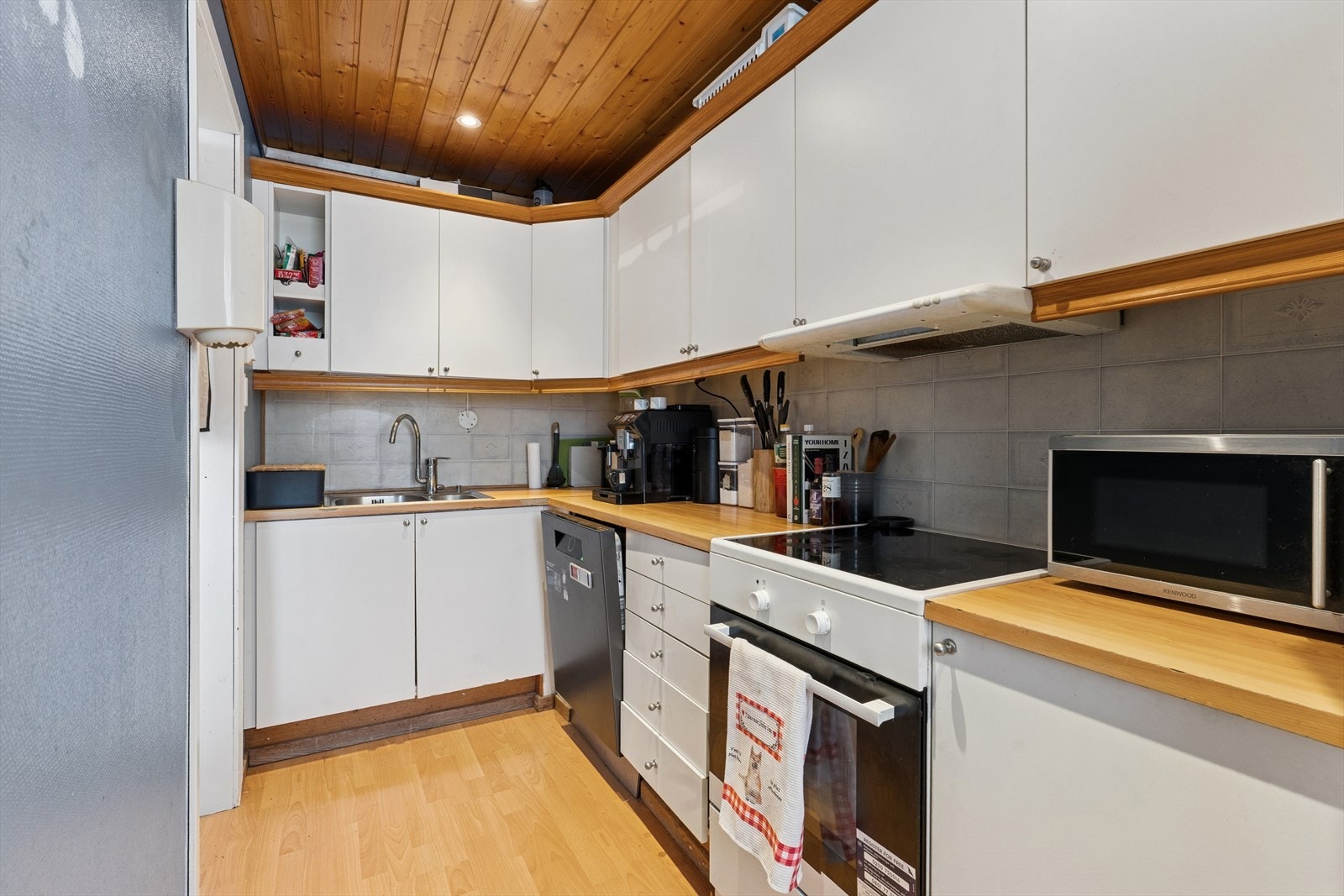 Kjøkkeninnredningen består av glatte skapfronter i både over- og underskap, og laminat benkeplate med dobbel oppvaskkum Galleribilde