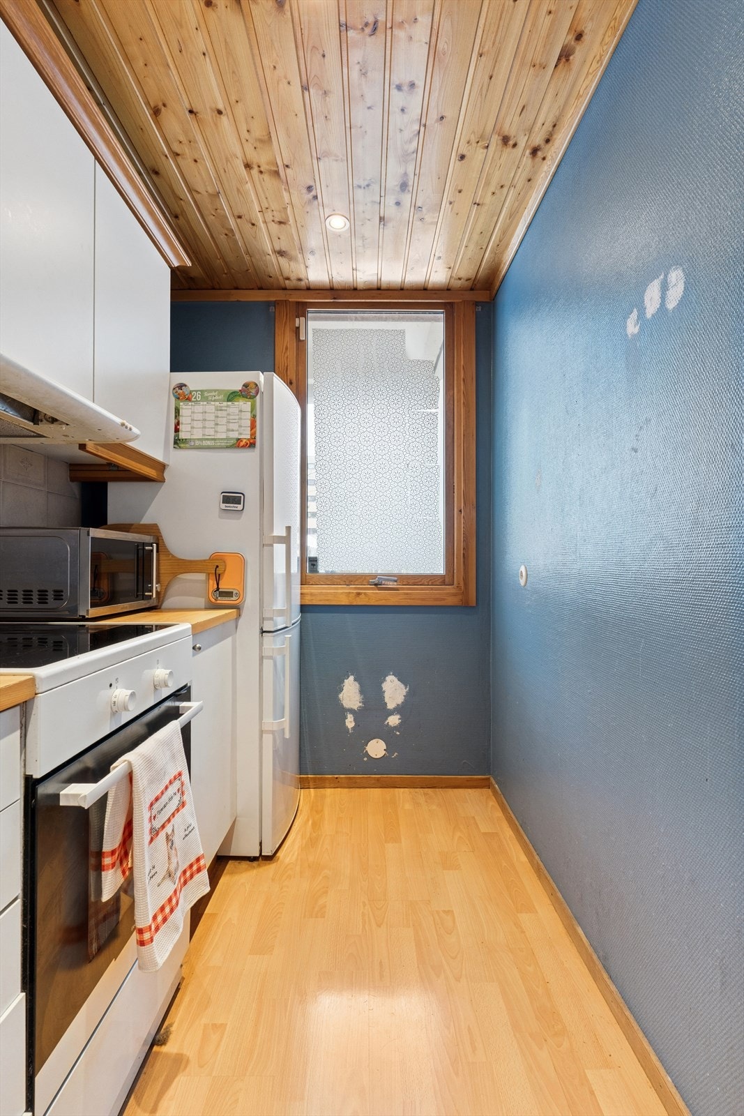 Kjøkkenet er avlangt utformet og har godt med skap- og benkeplass Galleribilde