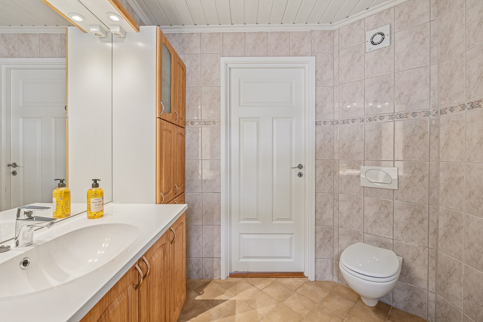 Badet er innredet med baderomsmøbel med heldekkende servantplate, speil med belysning, dusjkabinett og vegghengt toalett. Galleribilde