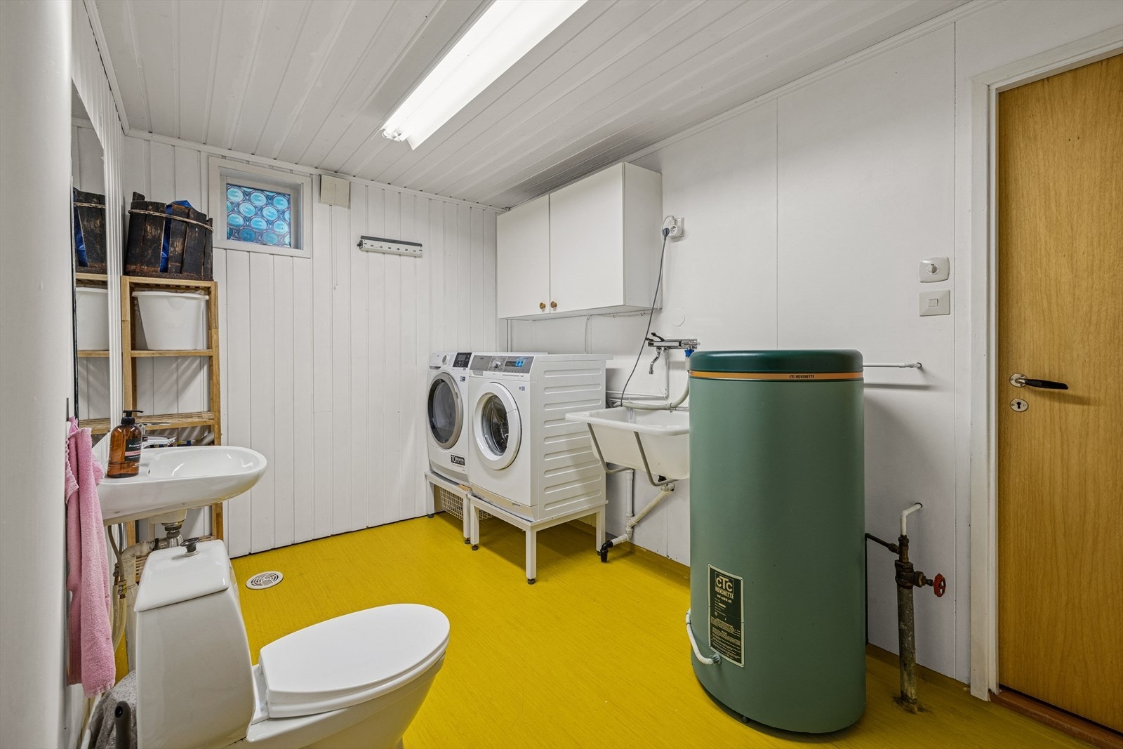 I underetasjen ligger boligens vaskerom, med panel på veggene og belegg på gulvet. Galleribilde