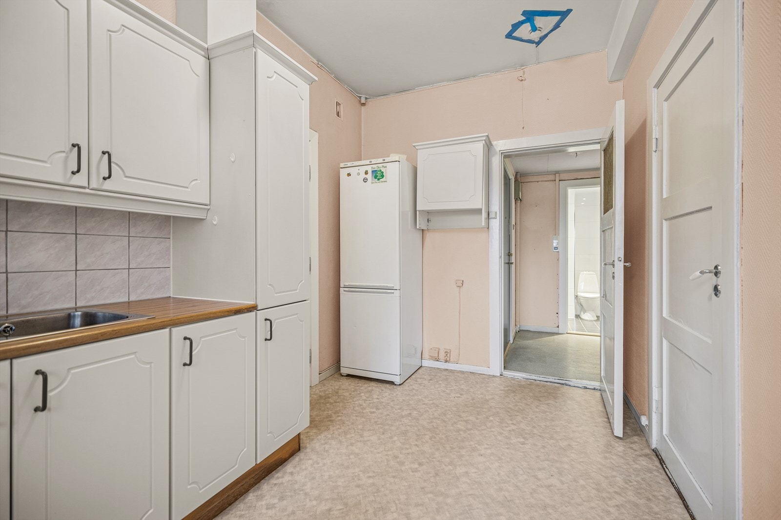 Kjøkken har i dag innredning med lakkerte 1-speils profilerte fronter, laminat benkeplate og fliser over benk. Galleribilde