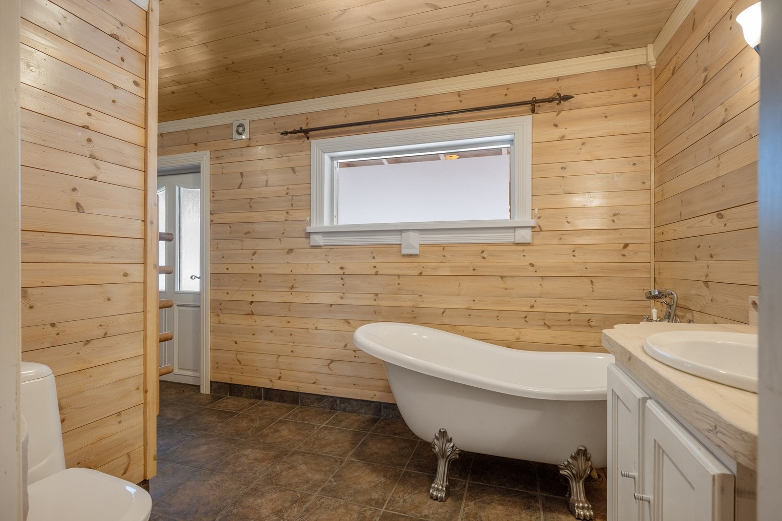 I første etasje er det et romslig bad- og vaskerom med flislagt gulv. Rommet har adkomst både fra inne og ute. Galleribilde