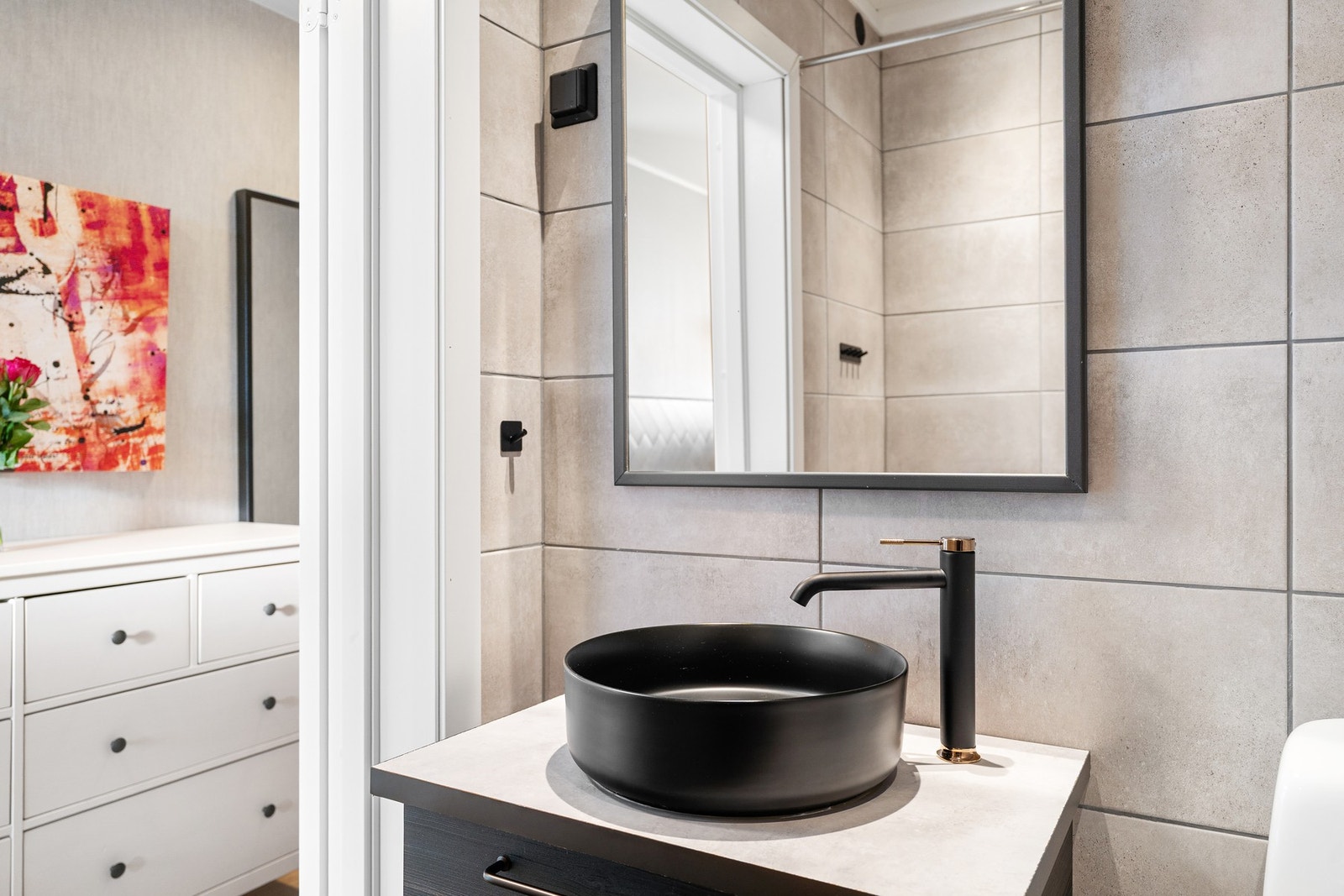 Sorte detaljer på servant og dusj gir badet et moderne uttrykk. Galleribilde