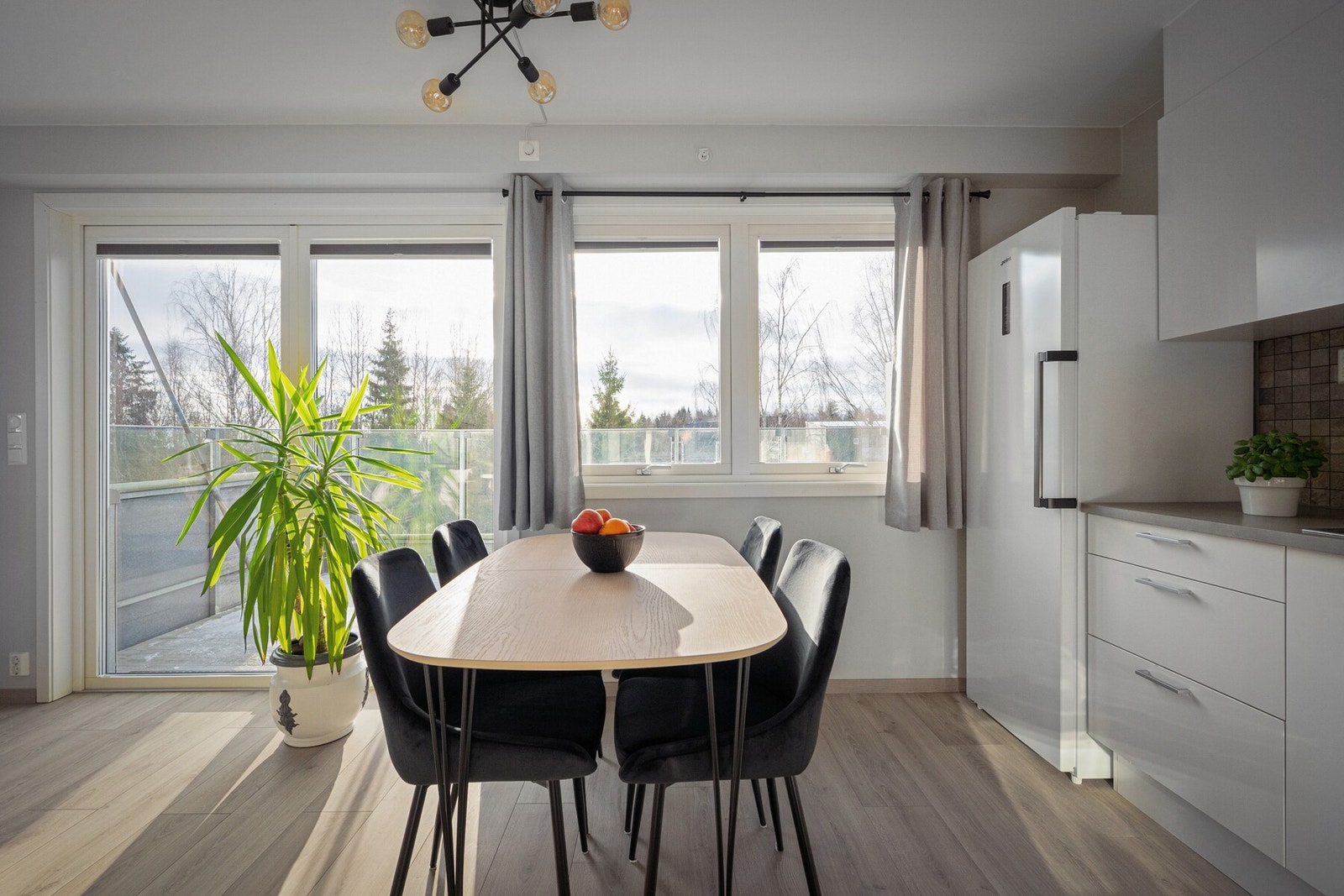 Leilighetens oppholdsrom fremstår som lyst, romslig og svært innbydende, med store vindusflater som slipper inn rikelig med naturlig lys. Galleribilde