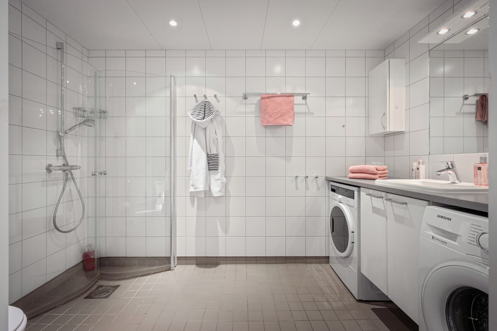 Romslig og praktisk bad med flislagte overflater, elektrisk gulvvarme og funksjonell planløsning. Galleribilde