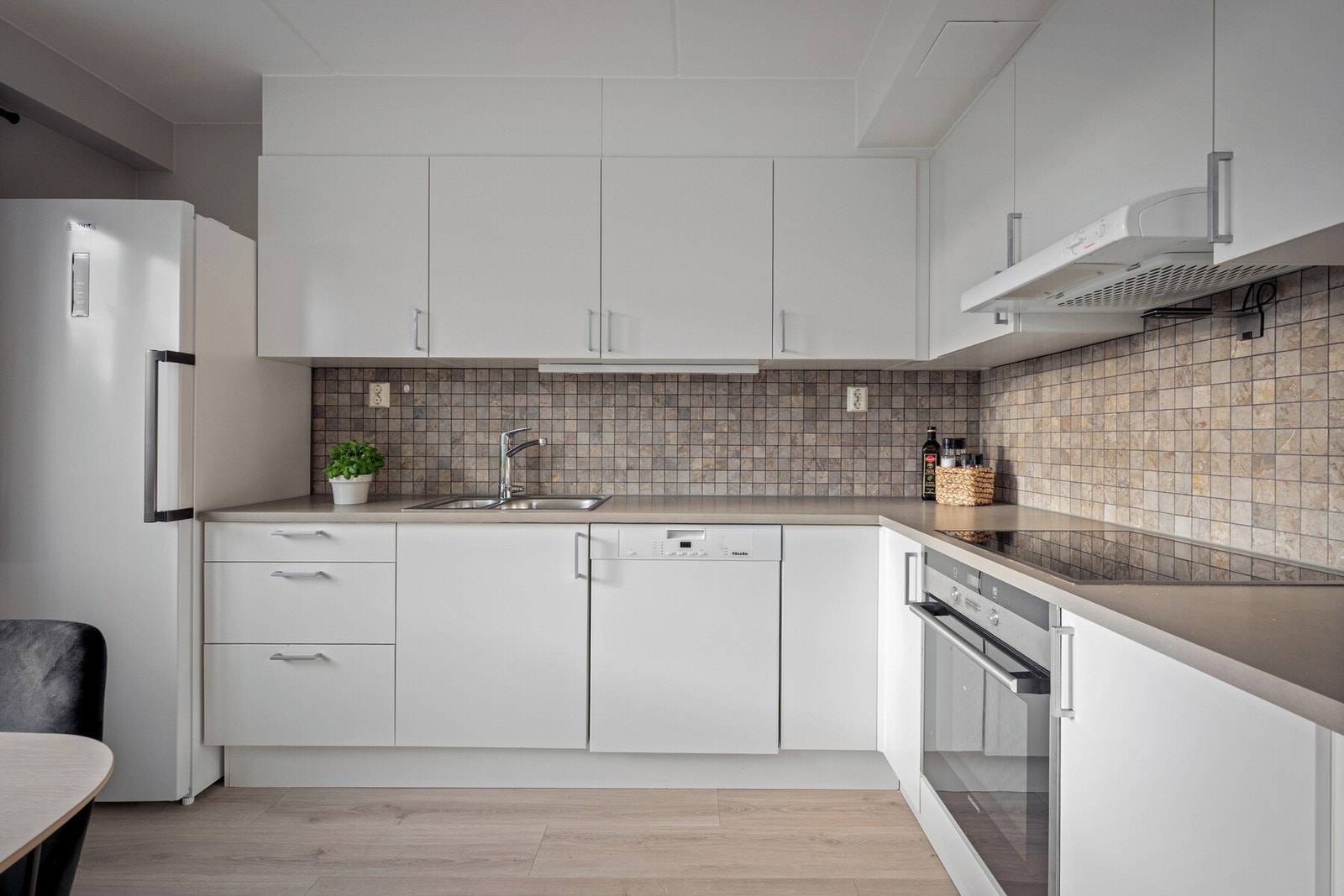 Løsningen er funksjonell og sosial, med naturlig plass til spisebord i tilknytning til kjøkkenet. Galleribilde