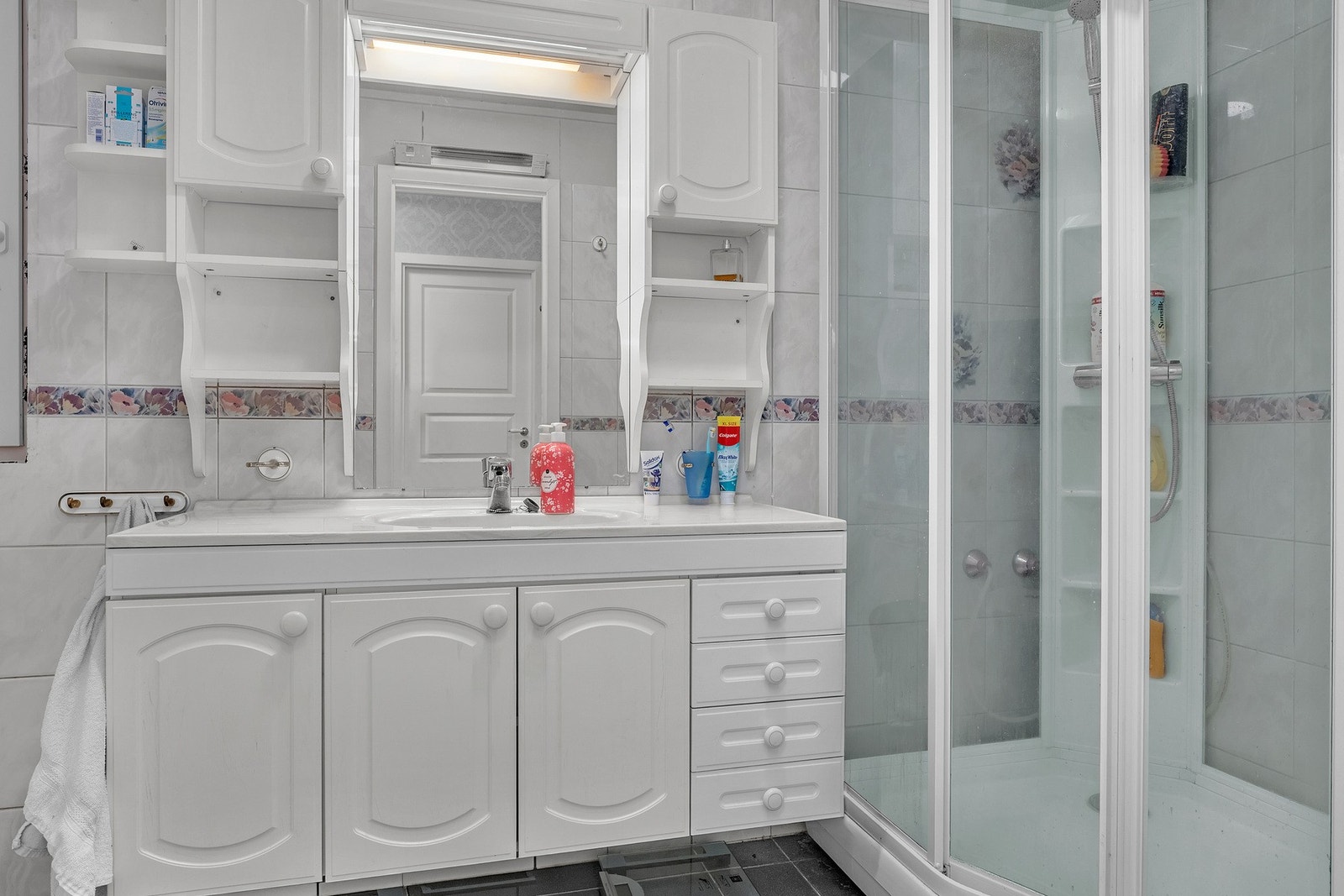 Flislagt bad med dusjkabinett, flere skap i innredning, toalett, bidet og servant Galleribilde