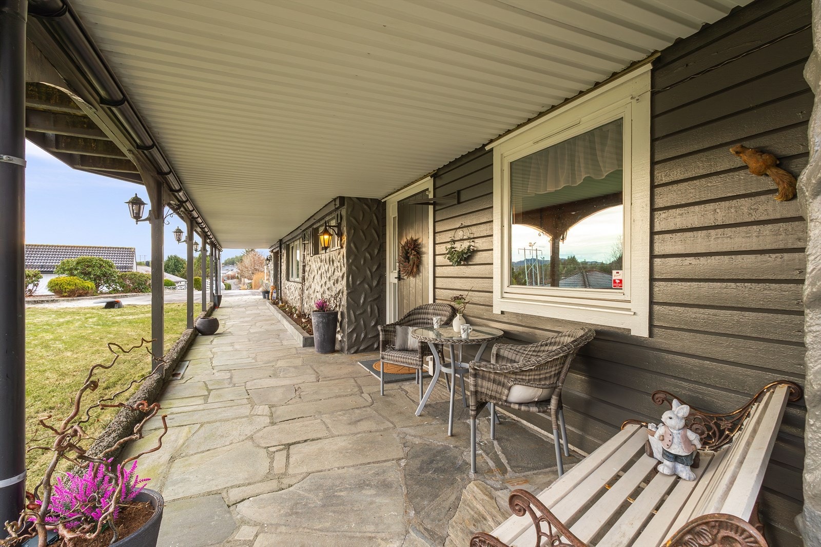 Inngangsparti med skiferheller, takoverbygg med utebelysning. Galleribilde