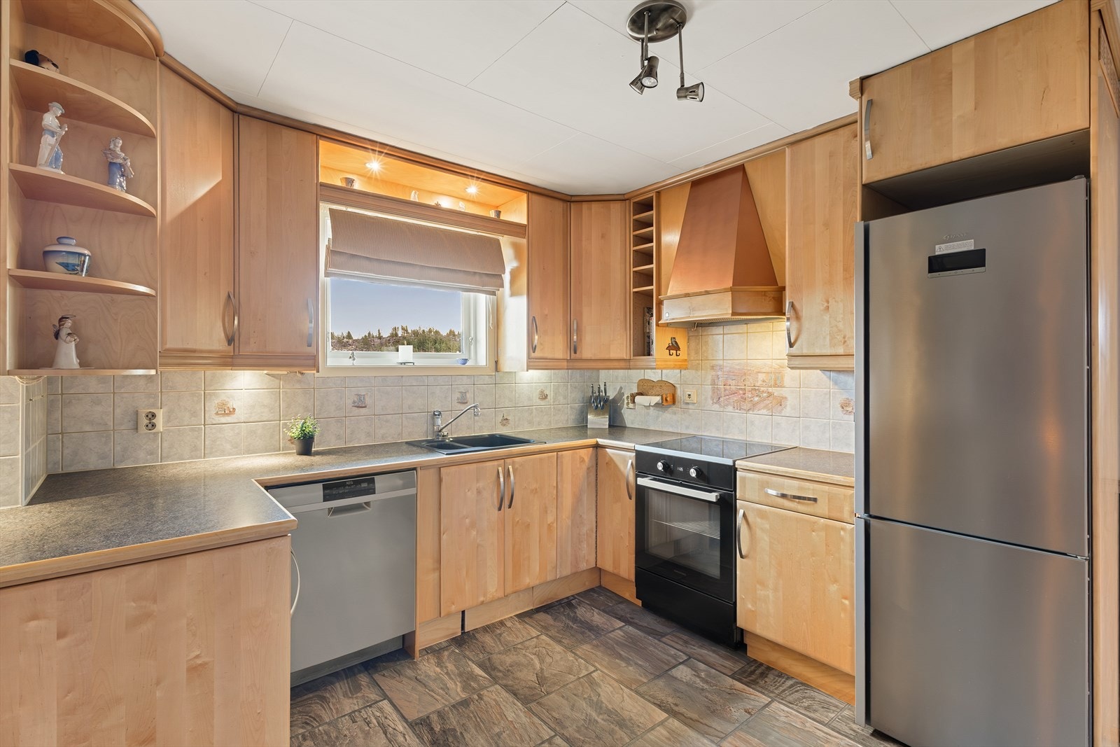 Kjøkkenet har innredning i Bjørk fra Drømmekjøkkenet. Benkeplaten er av laminat. Galleribilde