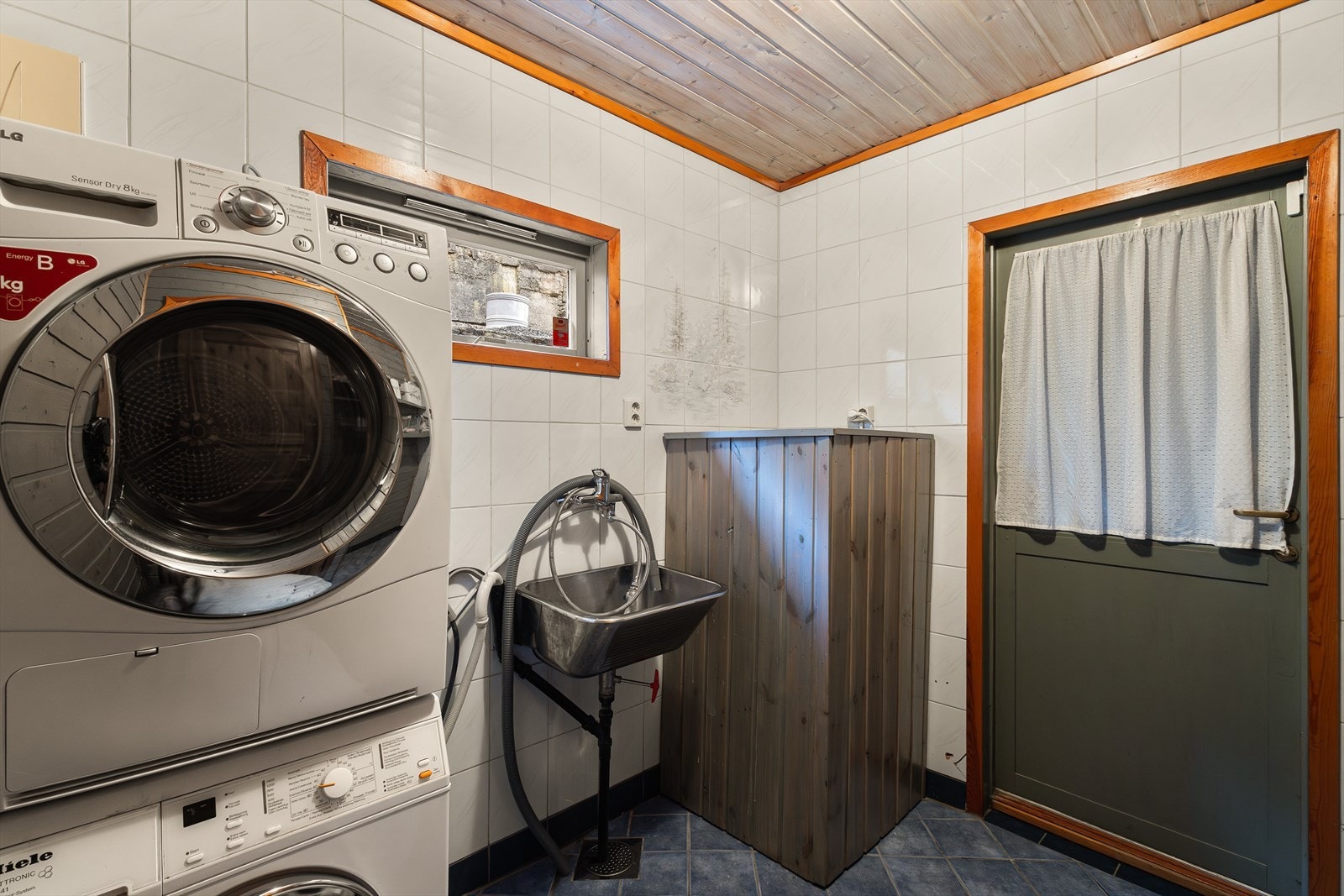 Romslig vaskerom med opplegg for vaskemaskin og tørketrommel. Varmekabler i gulvet. Galleribilde