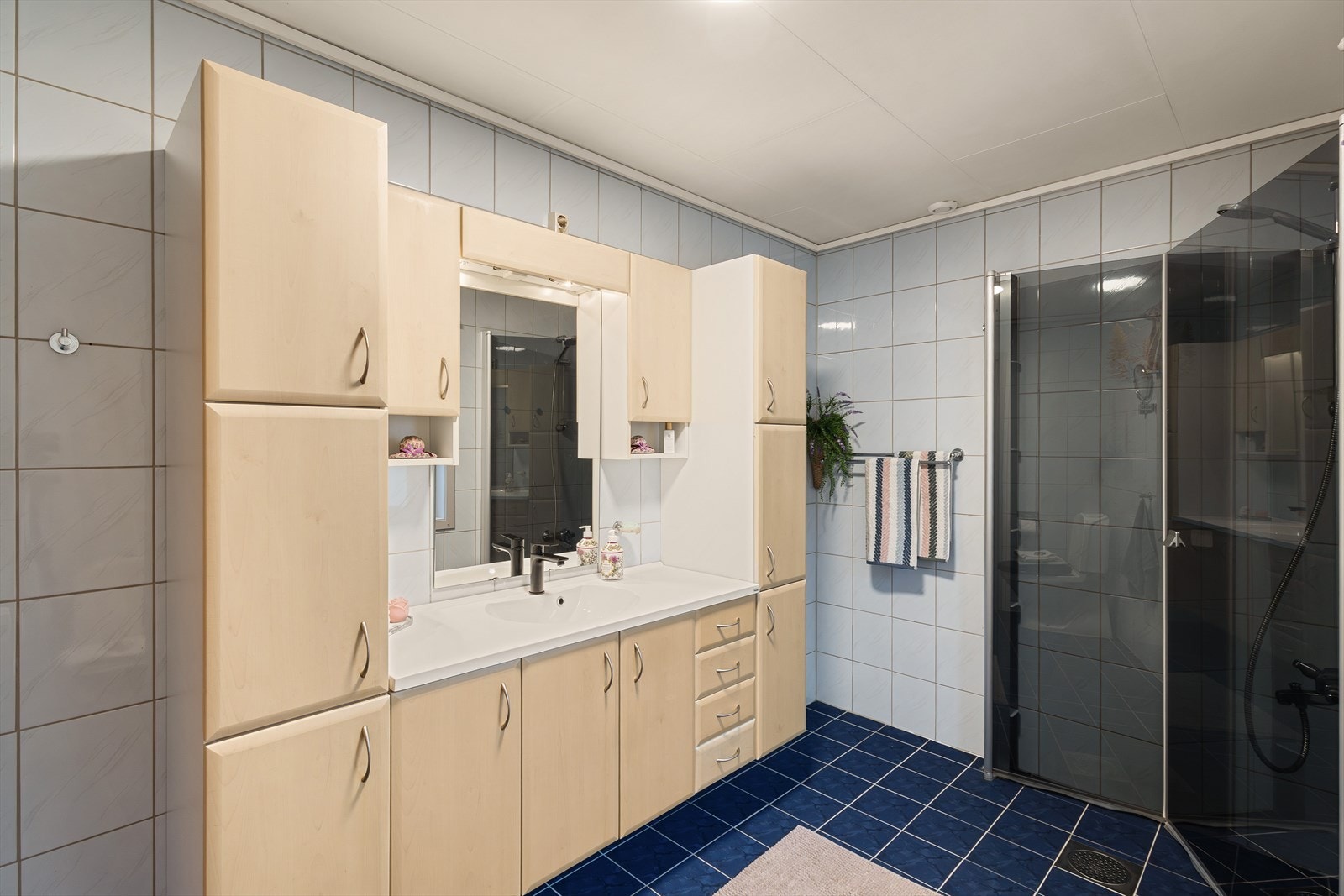 Badet er utstyrt med heldekkende servant med skuffer, dusj og wc. Galleribilde