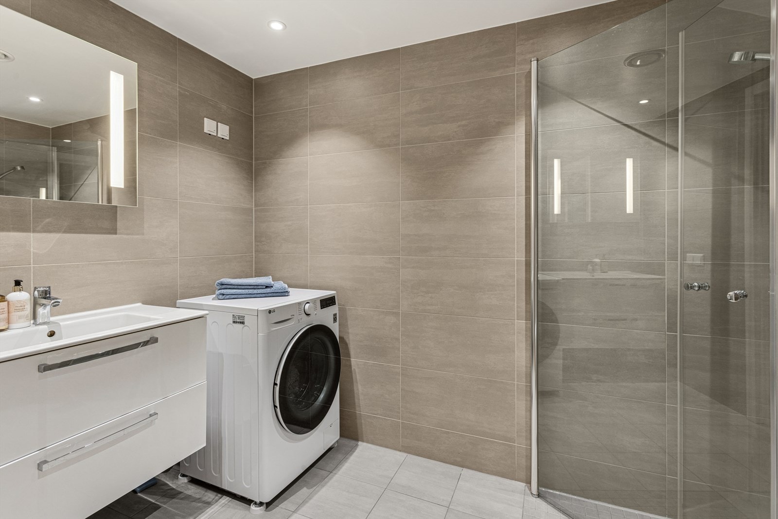 Moderne og og lekkert bad med plass og opplegg for tørketrommel i tillegg til vaskemaskin. Galleribilde