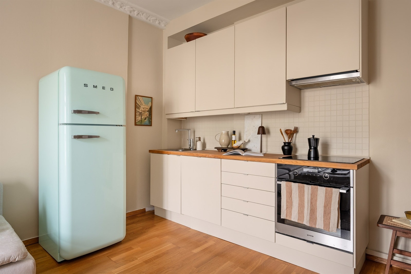 Innredningen er med glatte fronter og eik benkeplate med nedfelt, rustfri oppvaskkum. Hvitevarene er sømløst integrert og består av oppvaskmaskin og stekeovn med keramisk koketopp. Galleribilde