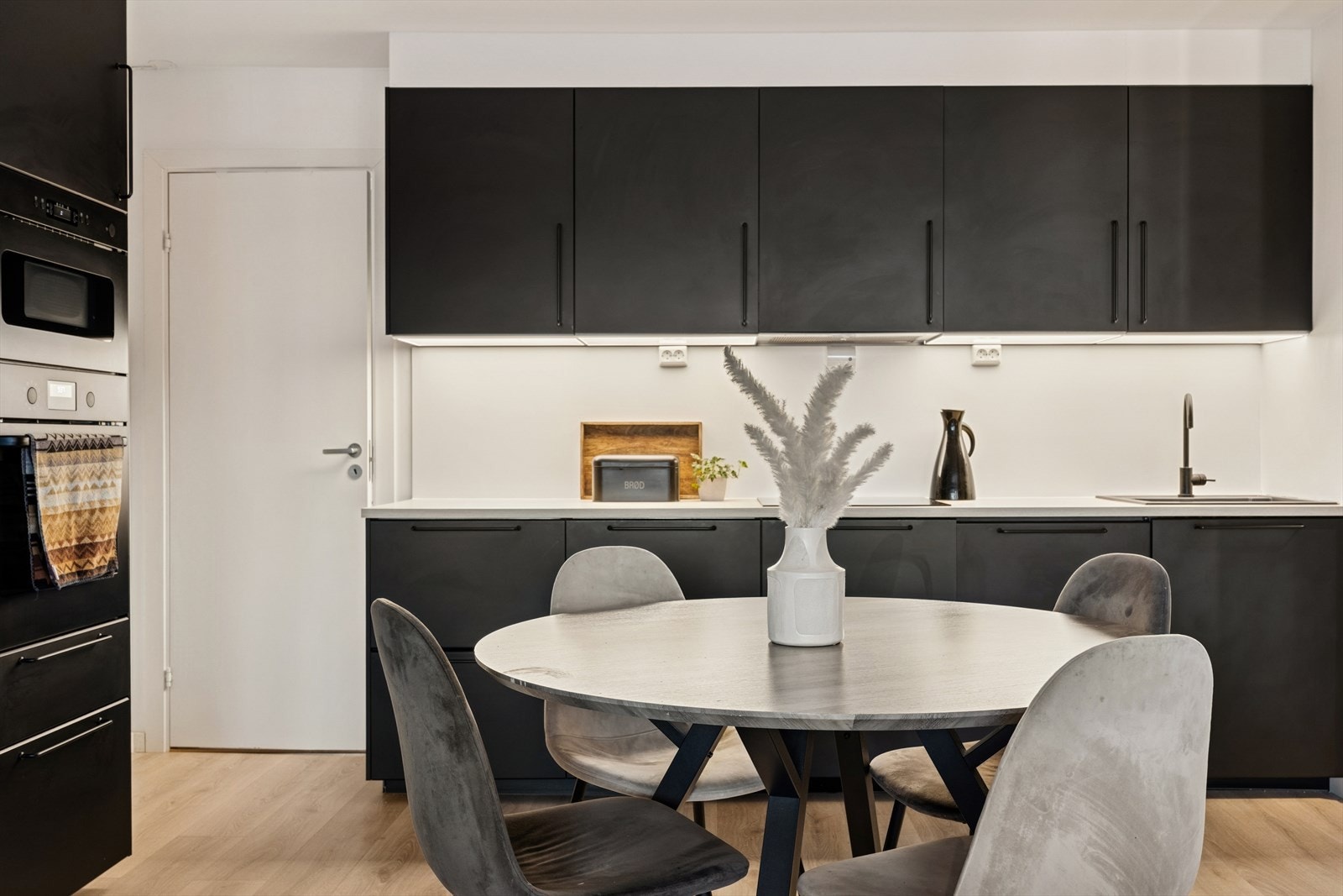 Stilren kjøkkeninnredning (2020) med folierte skrog med slette fronter og laminert benkeplate. Galleribilde