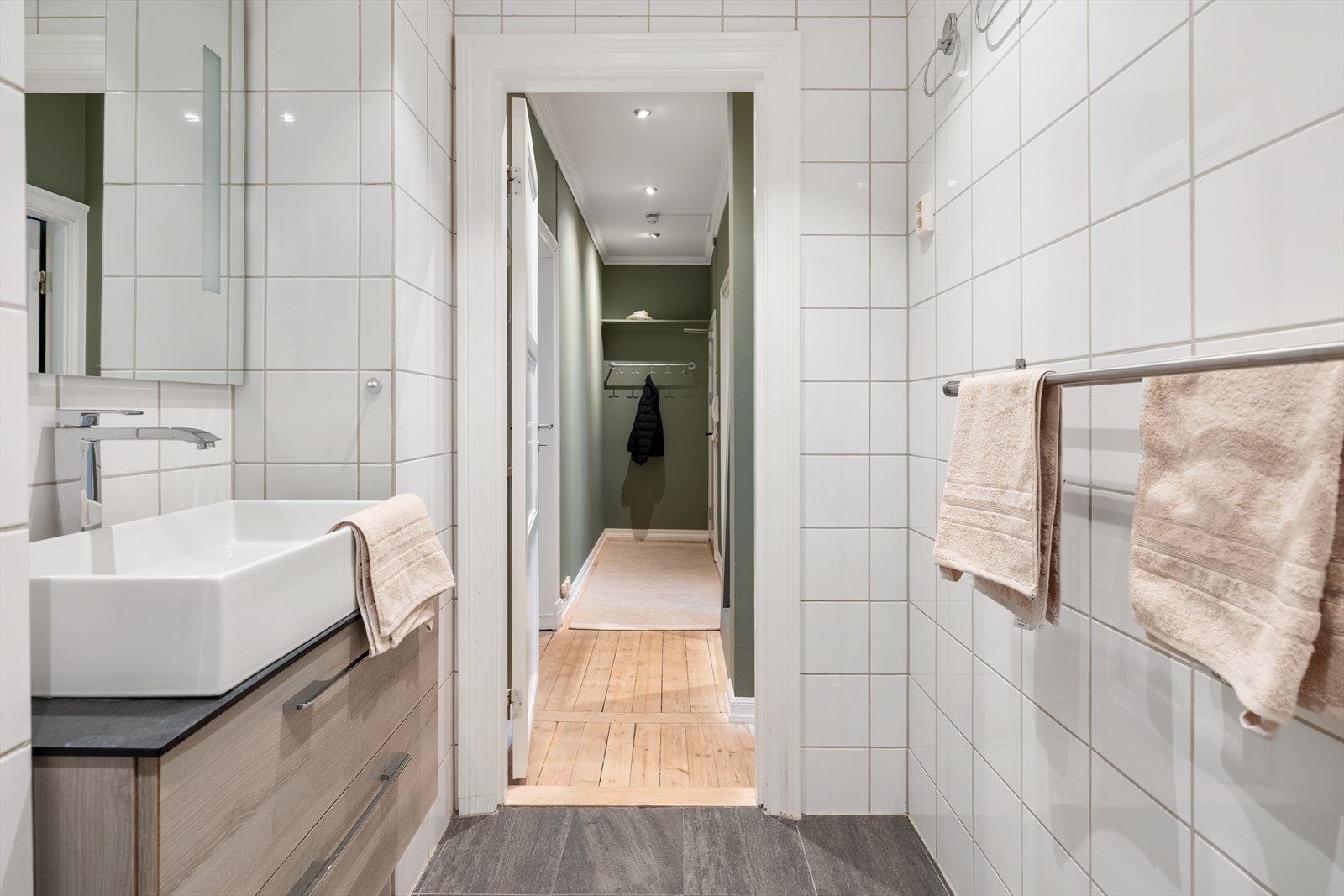 Innredning bestående av innfellbare dusjdører, naturlig avtrekk, servantskap og veggmontert wc. Galleribilde