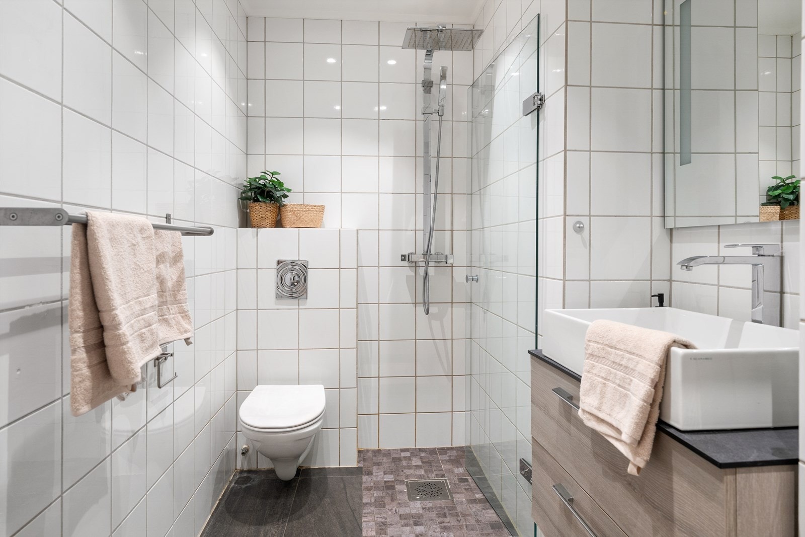 Badet har flislagt gulv og vegger, downlights i taket med malt himling. Det er gulvvarme. Galleribilde