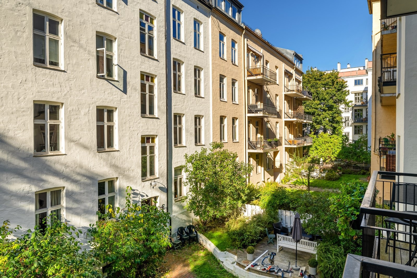 Utsikt fra balkong. Bygårdene i området er i klassisk stil fra slutten av 1800- tallet og begynnelsen av 1900-tallet, med flotte for-/bakhager, trær og beplantning. Galleribilde