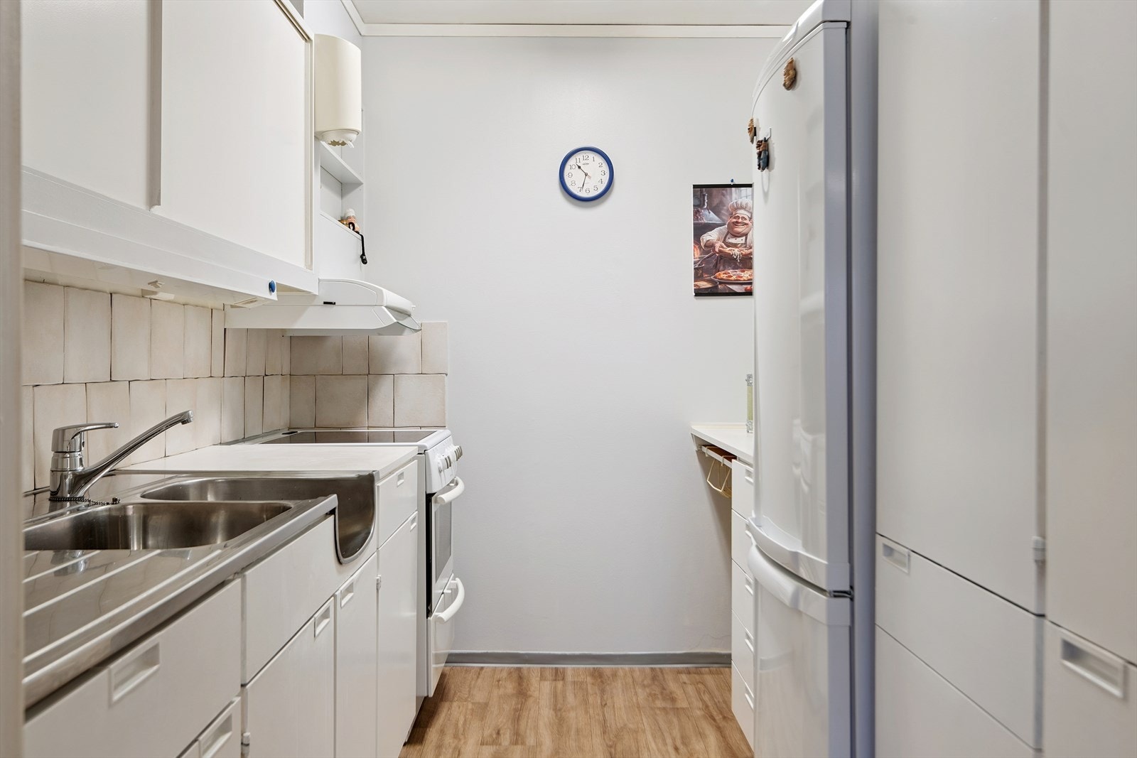 Kjøkkenet har eldre innredning med noe slitasje. Plass for frittstående hvitevarer. Galleribilde