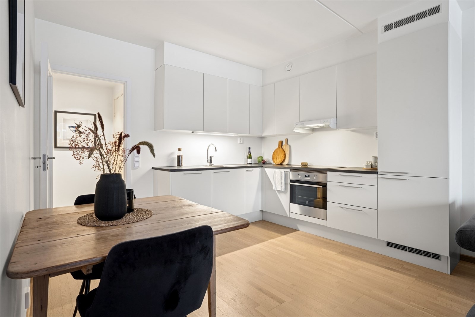 Stilrent kjøkken fra HTH i en moderne, funksjonell vinkelløsning med skaper foret opp til himling Galleribilde