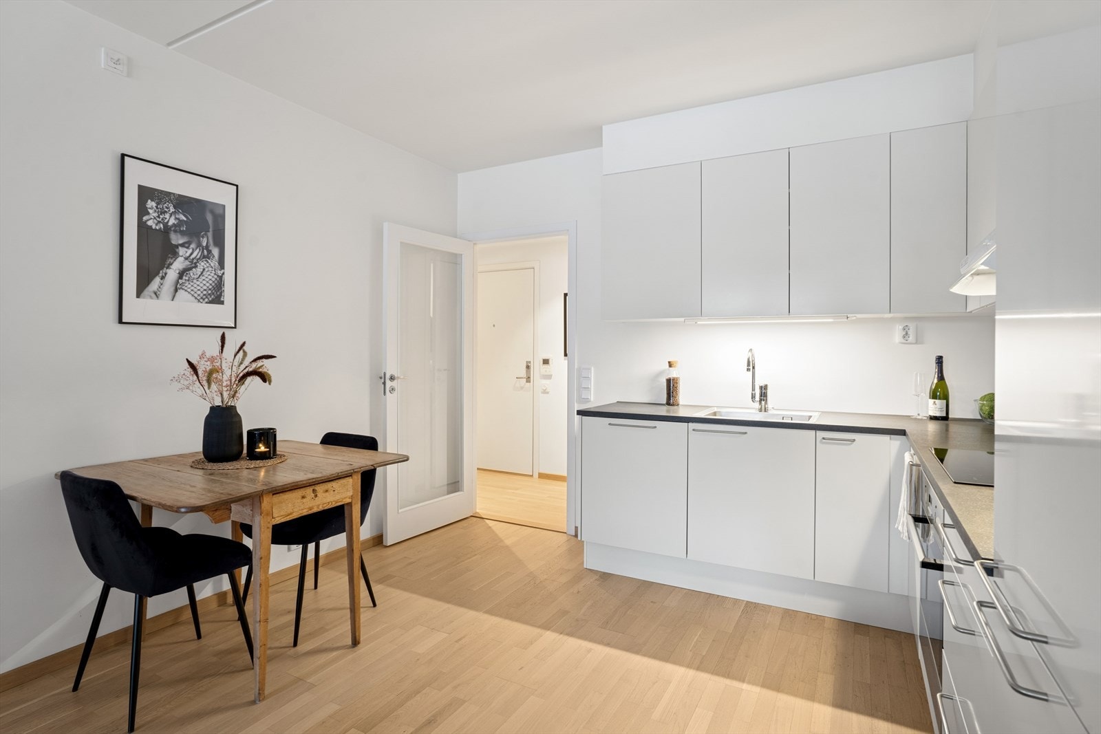 Innredningen har moderne glatte fronter, stål håndtak og en benkeplate i laminat som gir et moderne uttrykk Galleribilde