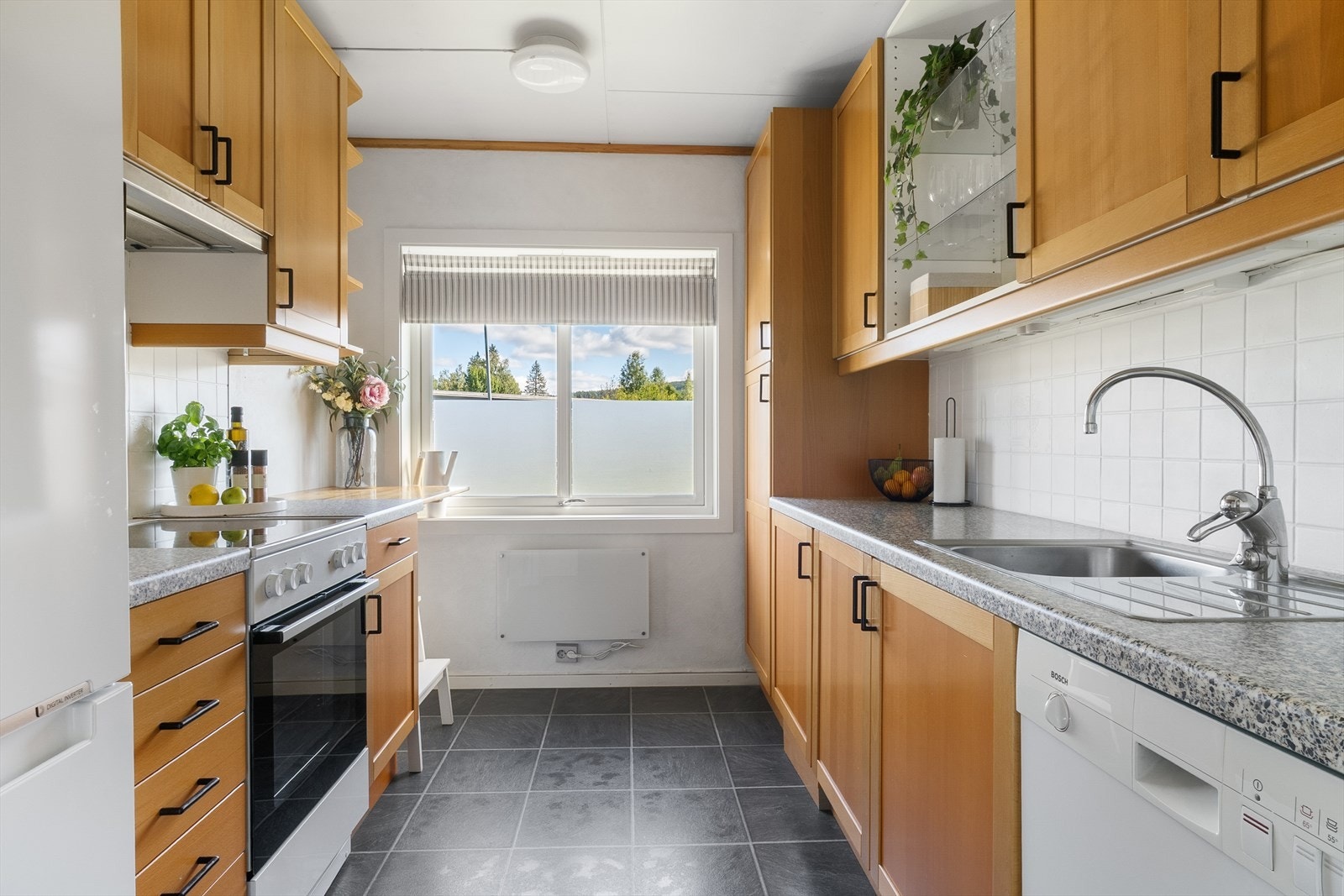 Kjøkkenet er innredet i en praktisk form og har godt med skap- og benkeplass. Galleribilde