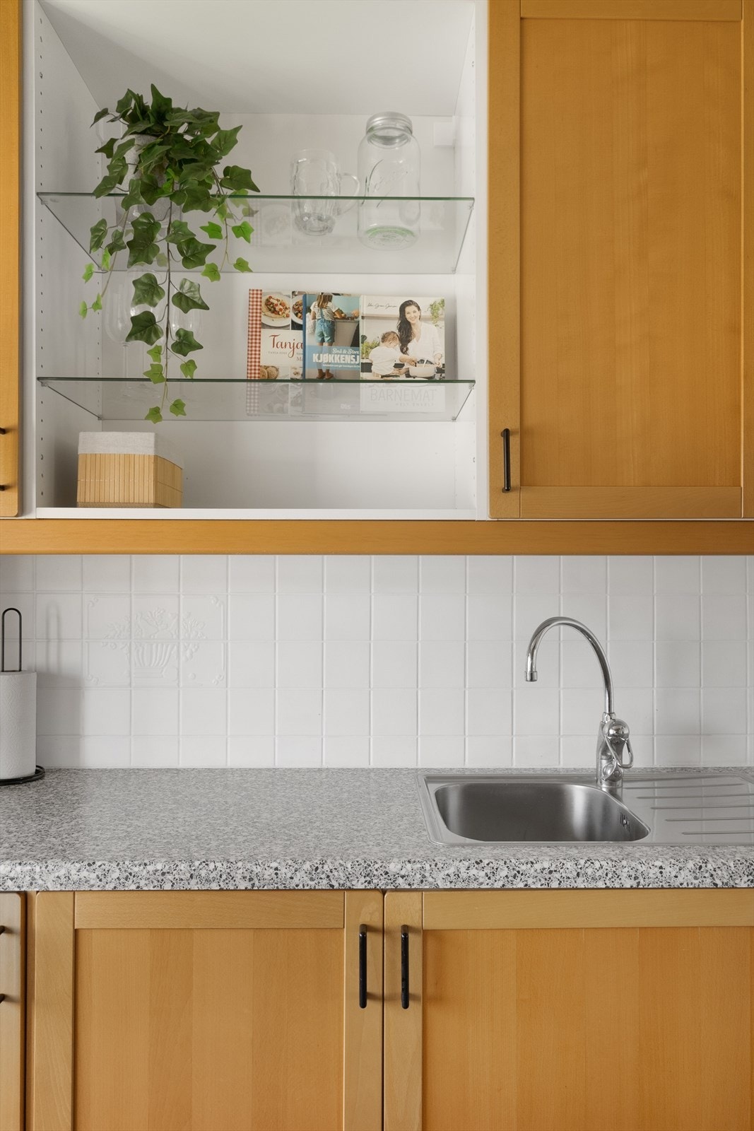 Veggen mellom benkeplaten og overskapene er flislagt. Galleribilde