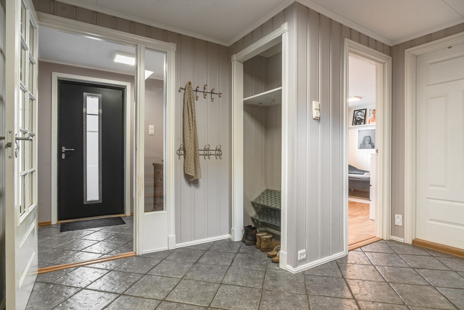 Gulvet har praktiske fliser og en åpen garderobe løsning som bidrar til god oppbevaringsplass for yttertøy. Galleribilde