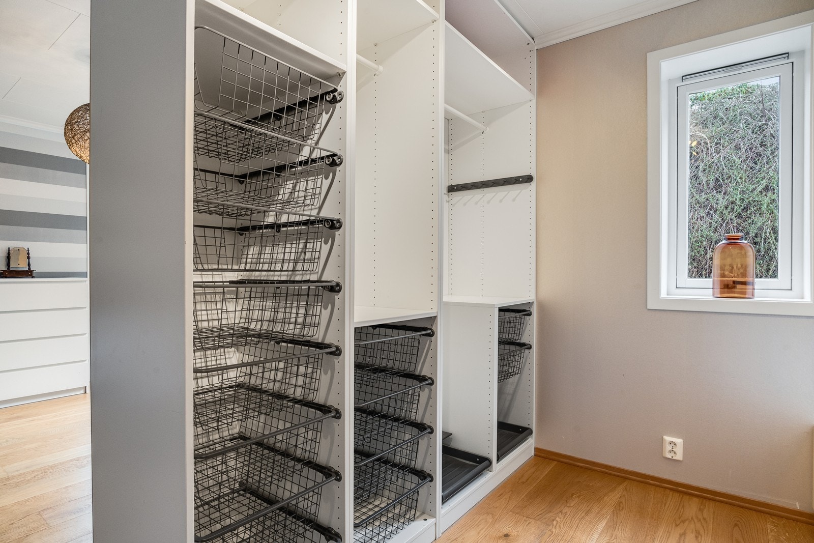 Soverommet har en åpen garderobeløsning som byr på praktisk og oversiktlig klesoppbevaring. Galleribilde