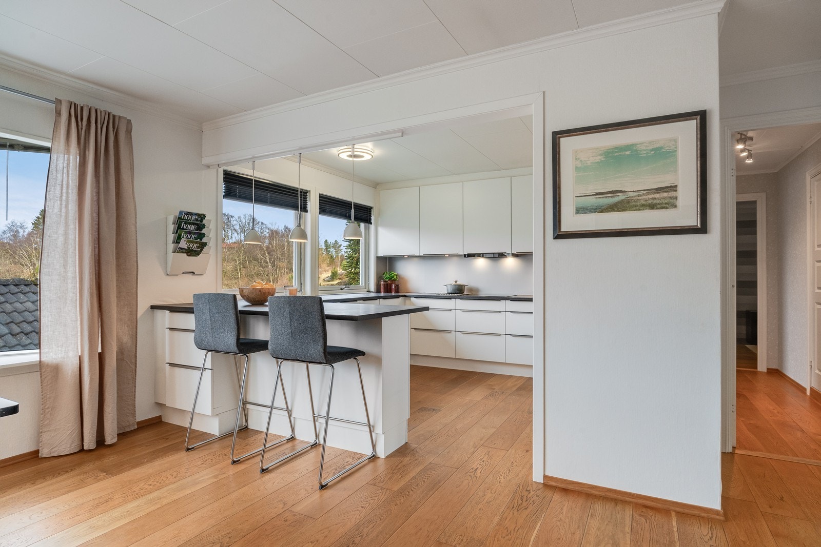 Lekkert kjøkken med moderne innredning og åpen løsning mot stuen. Galleribilde