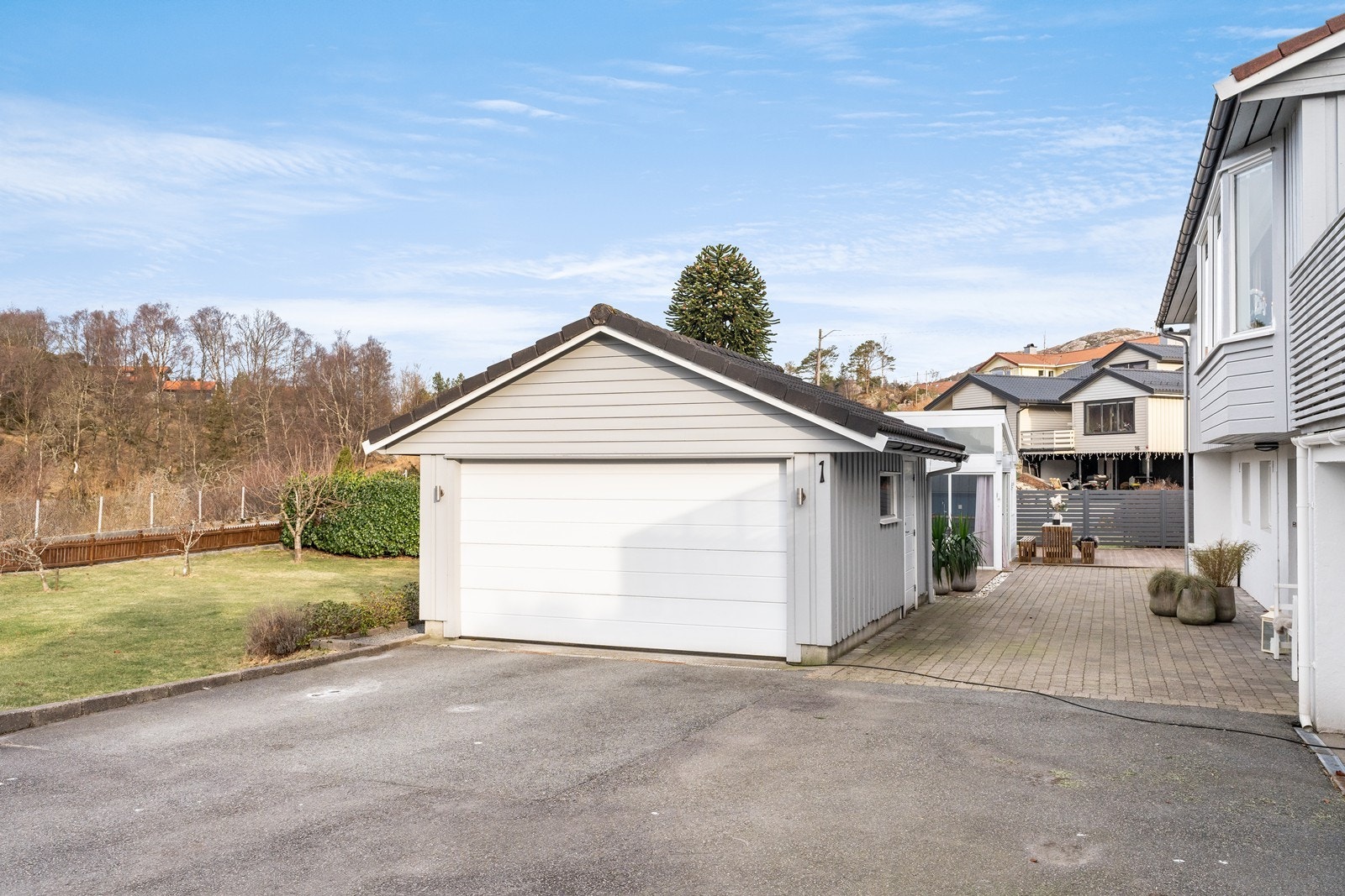 Asfaltert gårdsrom og praktisk garasje. Galleribilde