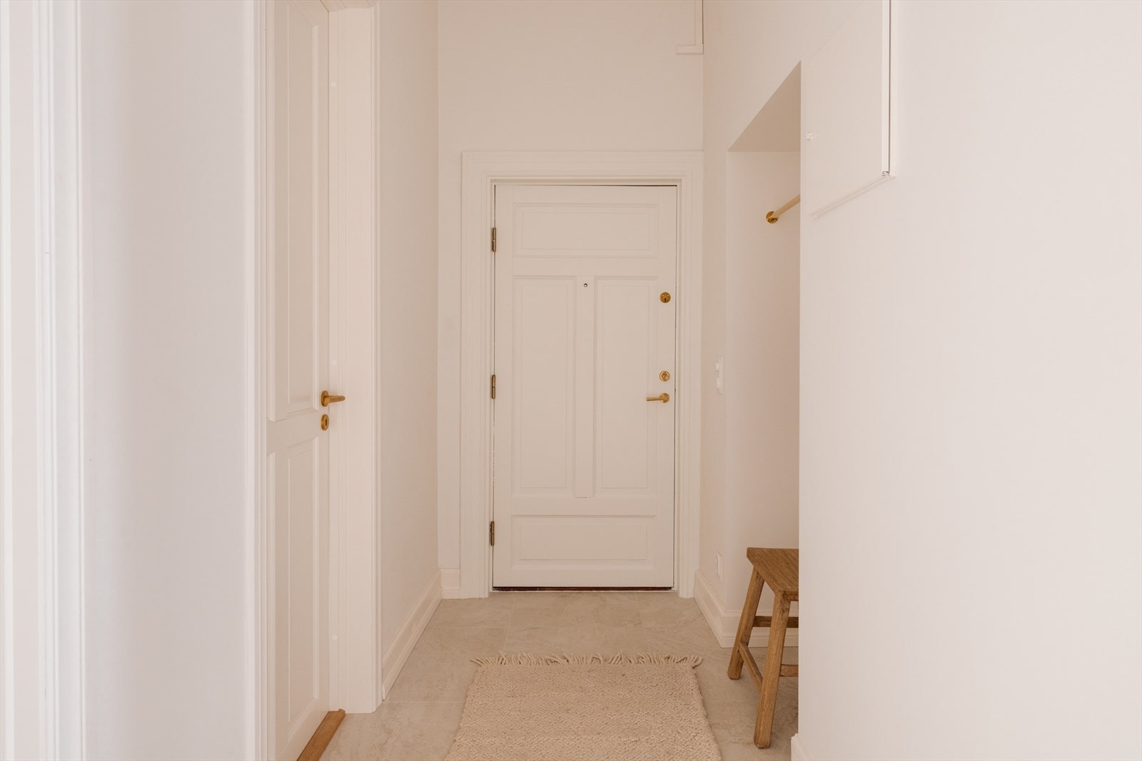 Yttergang med delikate 60x60 fliser på gulv og god takhøyde. Tidligere døråpning er praktisk utnyttet til oppheng av ytterjakker. Man kan fint sette inn flere hyller og skoskap i gangen, alt etter hva som er behovet. Galleribilde