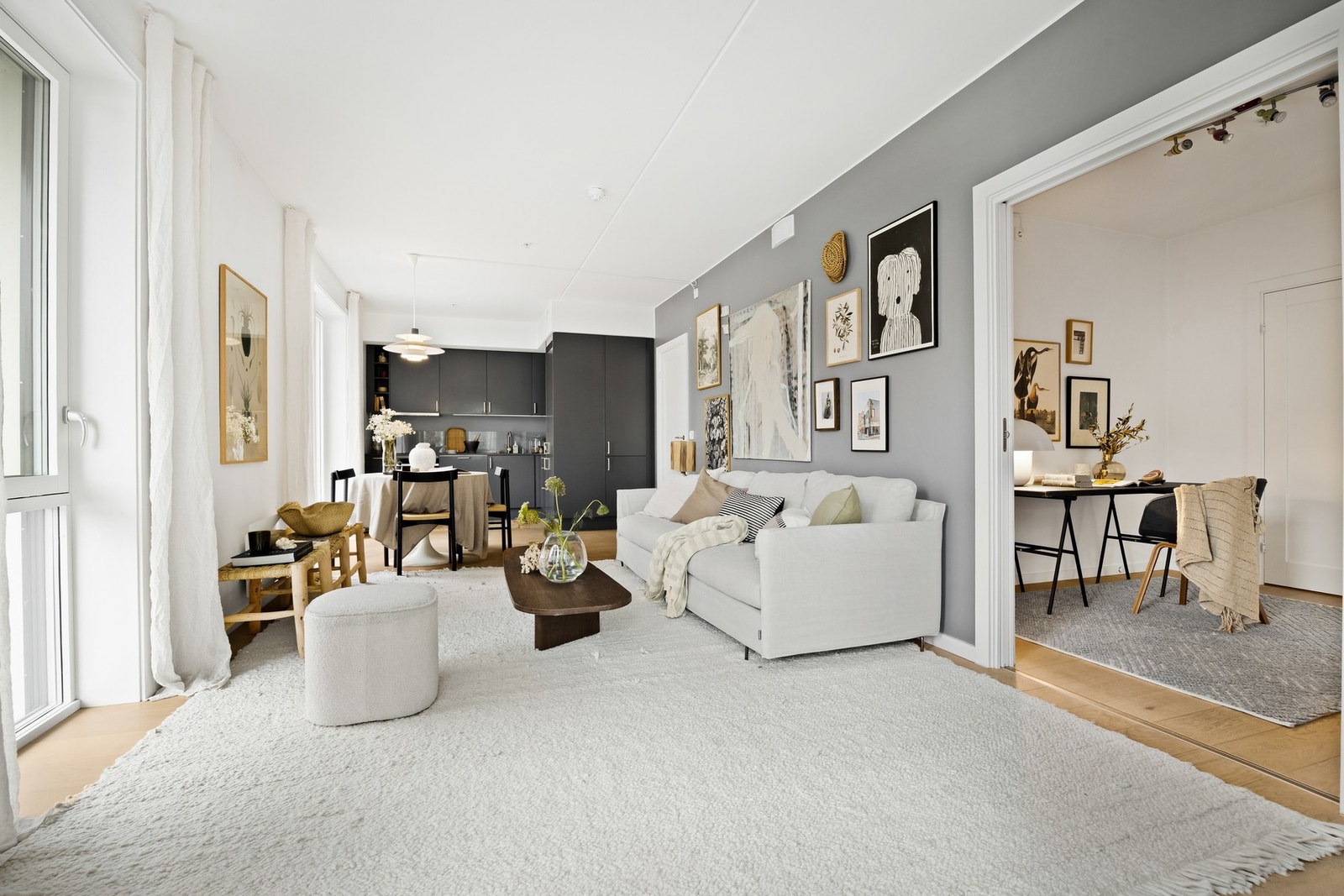Luftig og lettmøblert stue med åpen løsning mot kjøkken Galleribilde