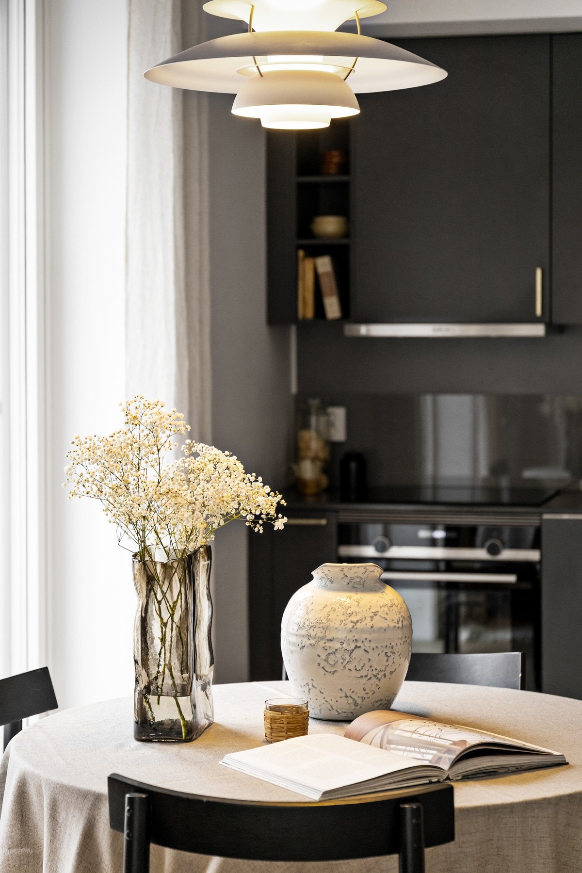 Innredning med slette fronter og benkeplate av kompositt. Glassplater på vegg over kjøkkenbenk. Galleribilde