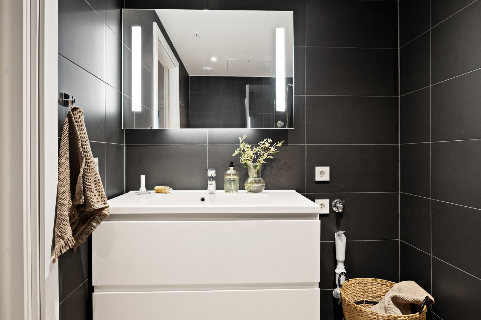 Skuffer under speilskap og opplegg for vaskemaskin på badet. Galleribilde