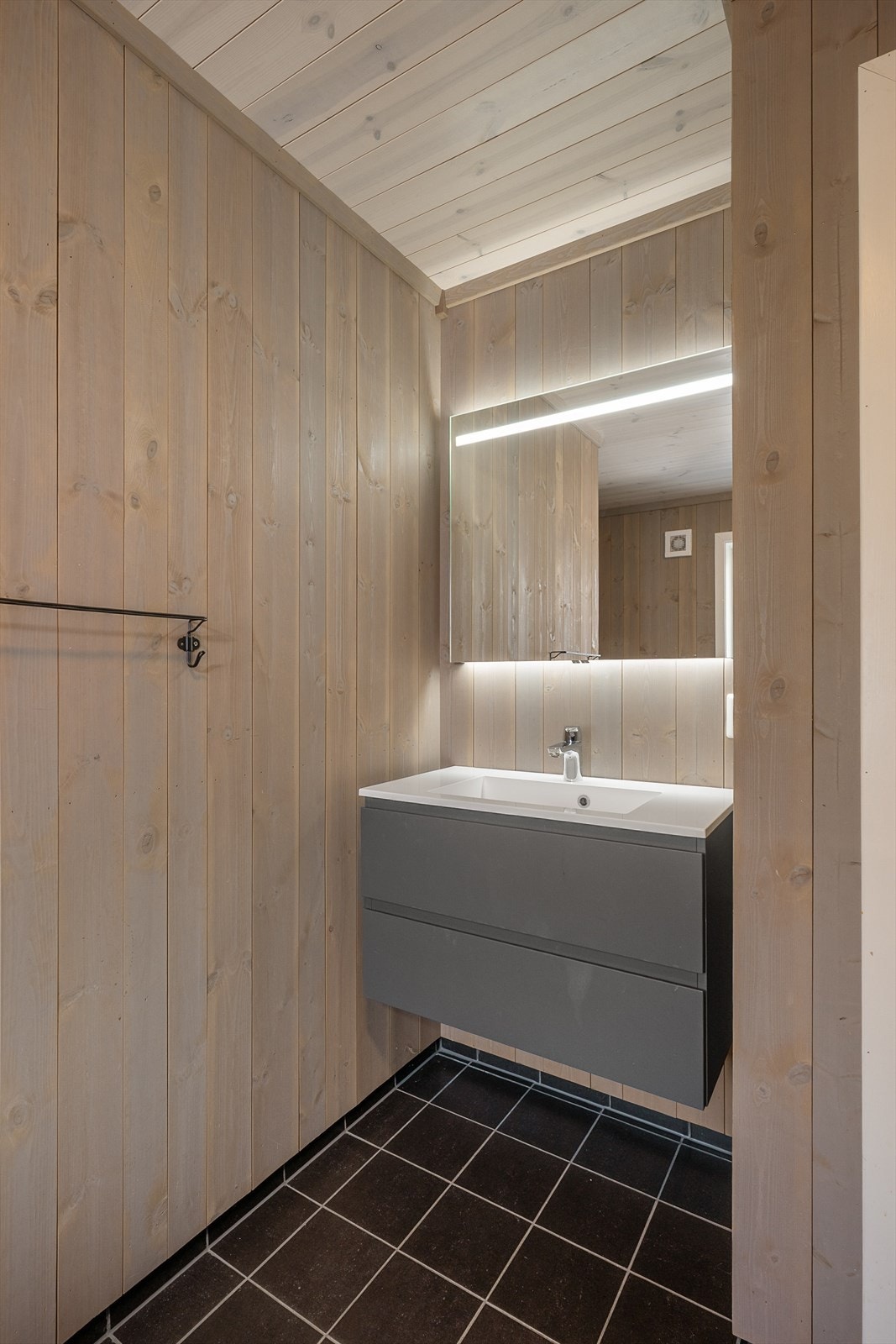 Moderne baderomsinnredning med heldekkende servant og god oppbevaringsplass. Galleribilde