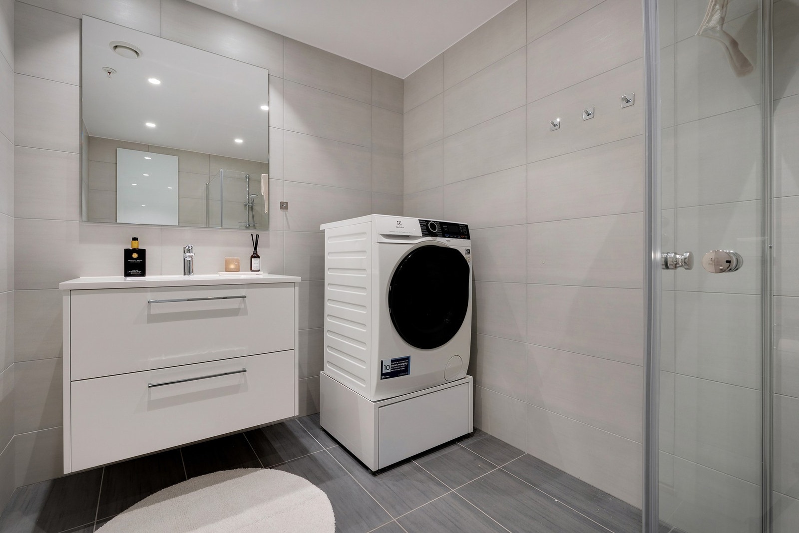 Boligen har et lekkert bad med fliser på gulver og vegg. Galleribilde