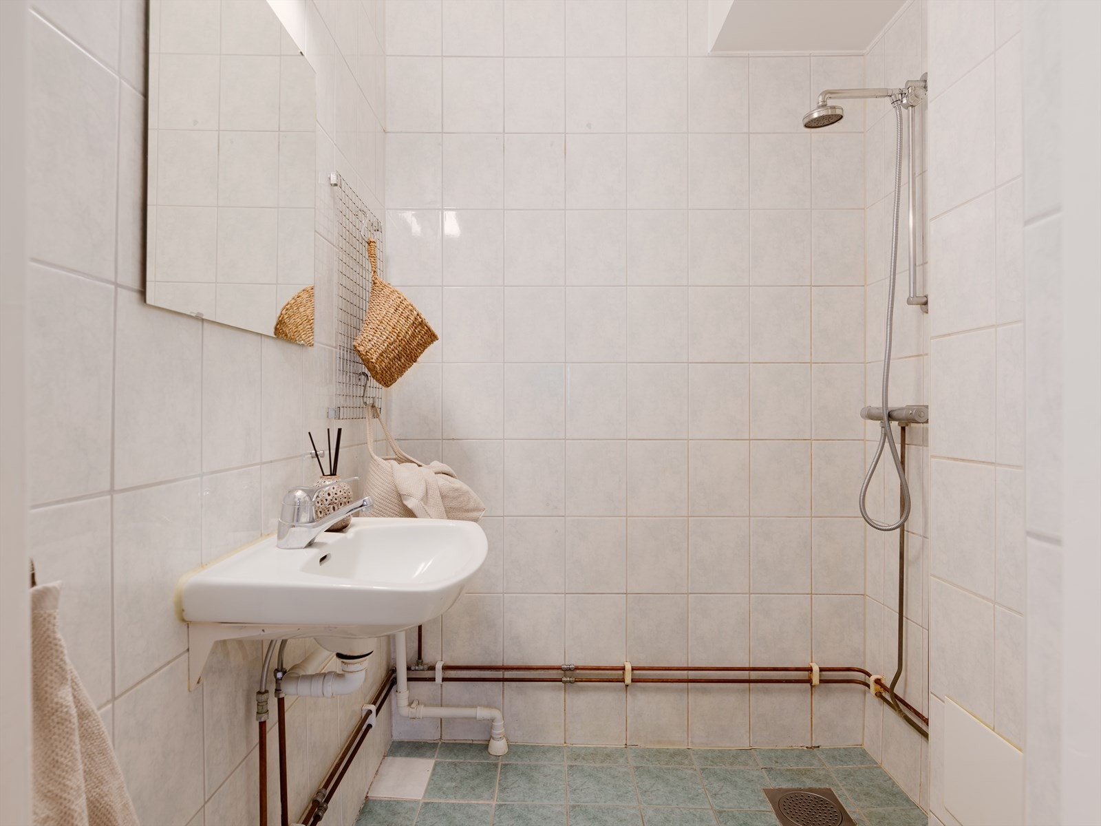 Badet er innredet med dusjhjørne, servant med overspeil, overskap og klosett. Galleribilde