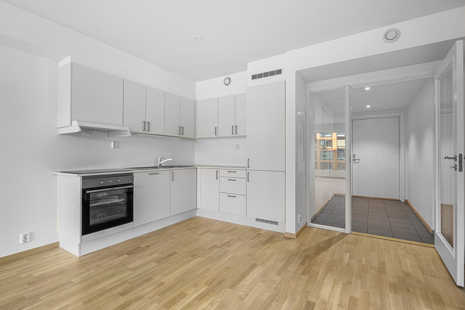 Pent kjøkken med integrerte hvitevarer og mye skap/benkeplass. Galleribilde